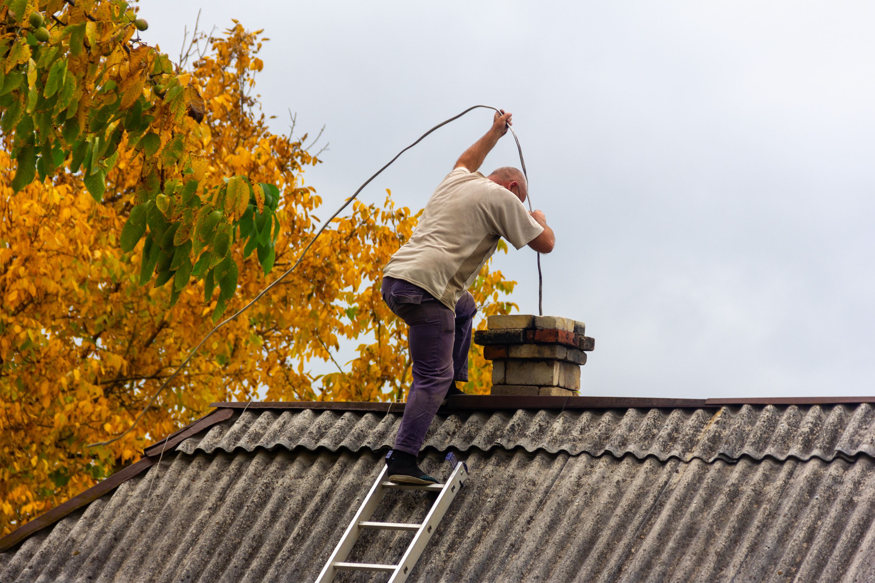 Man performing chimney sweep service